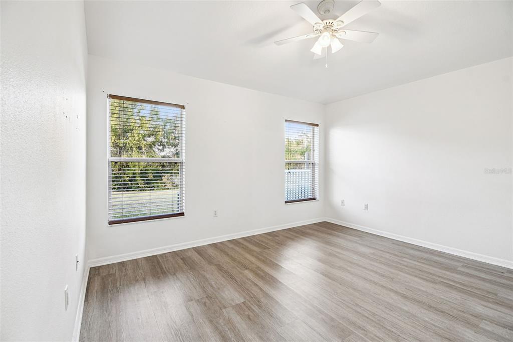 11478 Weston Course Loop Riverview, FL 33579 - Photo 20 of 30 an empty room with wooden floor fan and windows