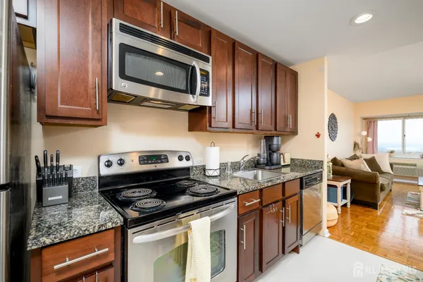 a kitchen with stainless steel appliances granite countertop a stove microwave and sink