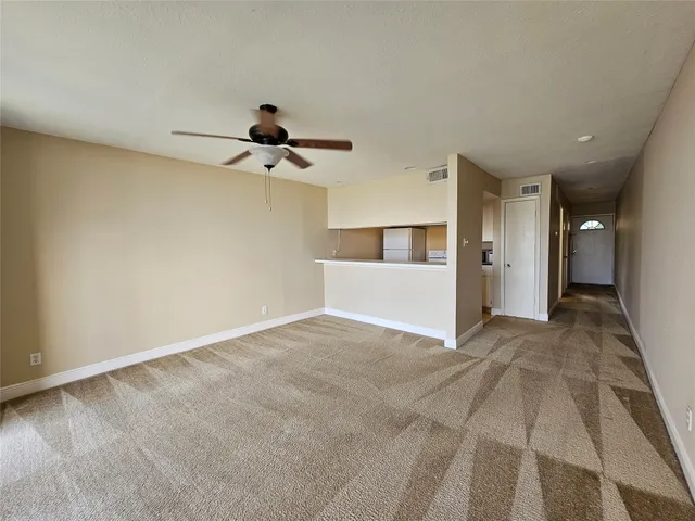 a view of a livingroom with wooden floor and a ceiling fan