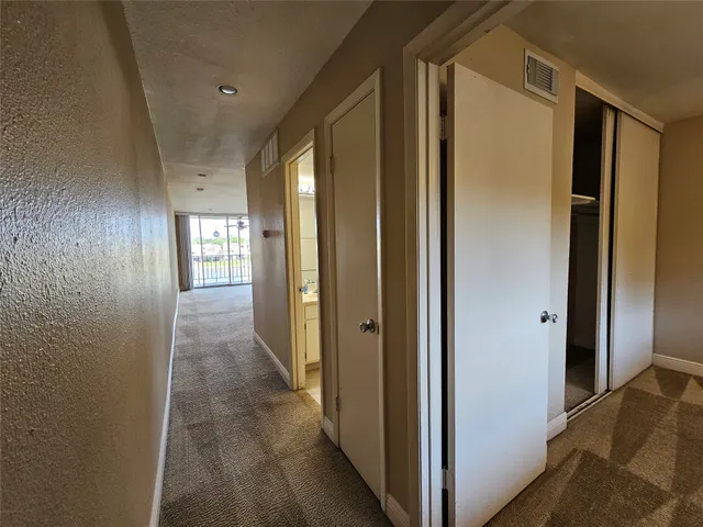 a view of hallway with windows and closet