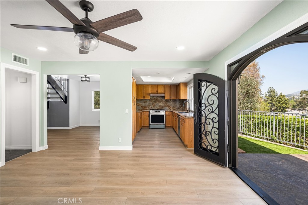 5554 East Vista Del Rio Anaheim, CA 92807 - Photo 16 of 42 a view interior of a house with wooden floor windows and a ceiling fan
