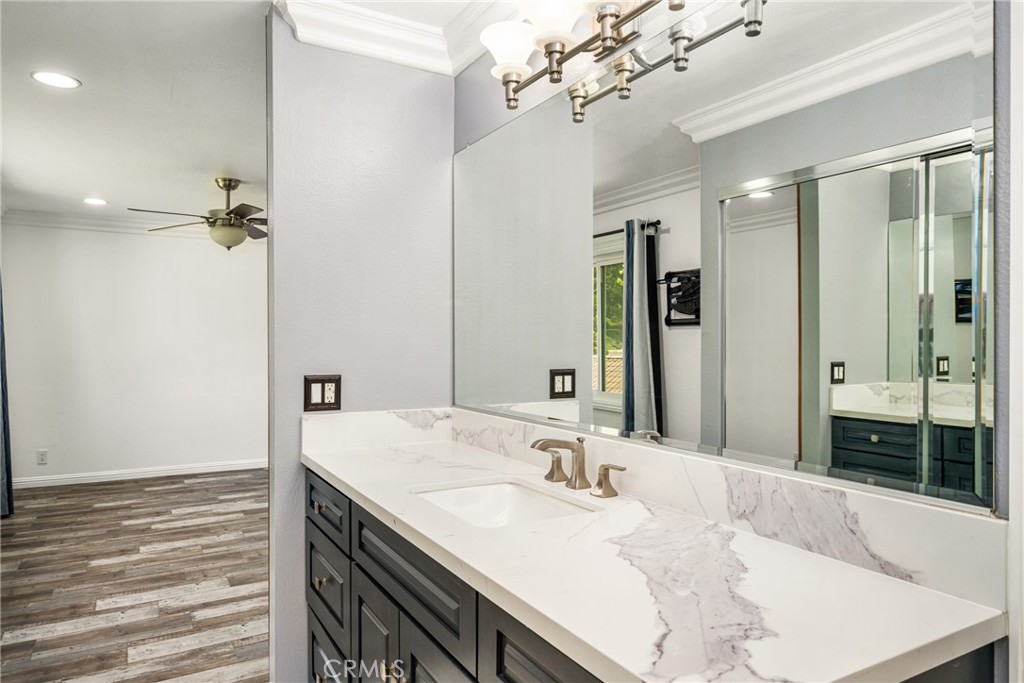 5554 East Vista Del Rio Anaheim, CA 92807 - Photo 35 of 42 a bathroom with a granite countertop sink a large mirror and a shower