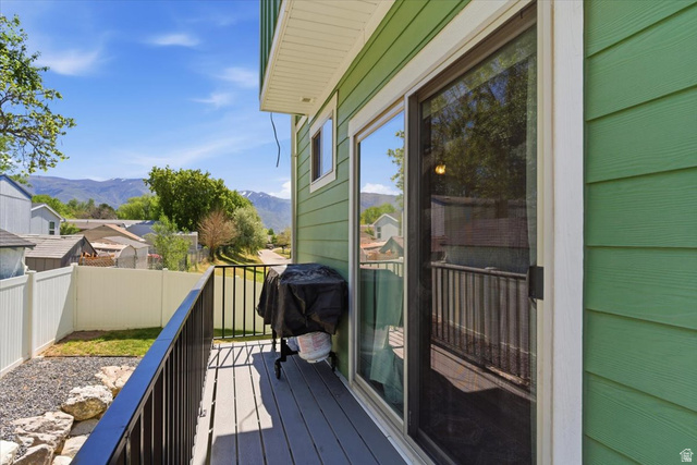 370 West Knights Lane Layton, UT 84041 - Photo 4 of 31 Outdoor balcony featuring composite decking, black metal railings, and a sliding glass door