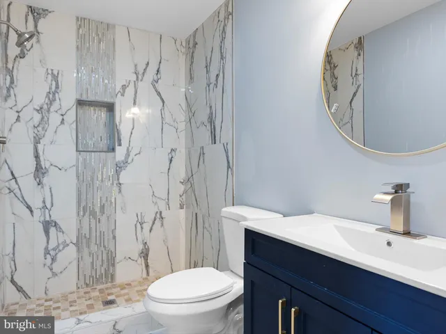 a bathroom with a sink a toilet and a mirror