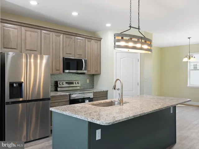 a kitchen with stainless steel appliances granite countertop a sink refrigerator and microwave