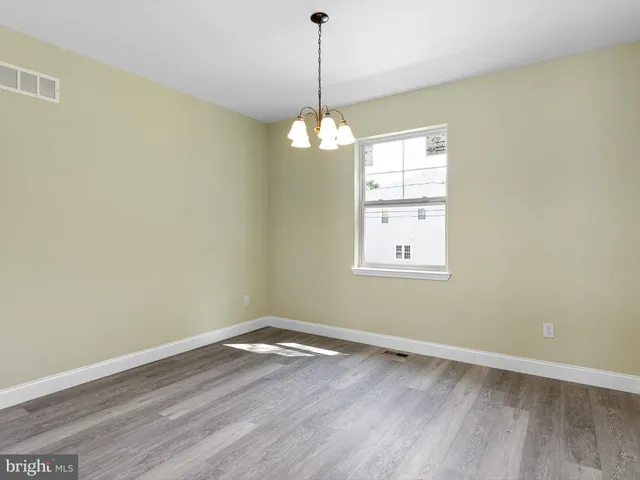 a view of wooden floor chandelier and window in a room