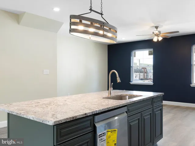 a kitchen with a granite countertop sink stainless steel appliances and chandelier