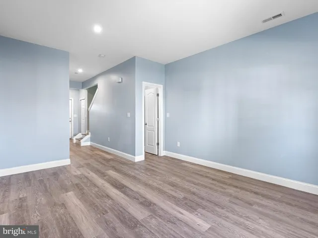 a view of an empty room with wooden floor