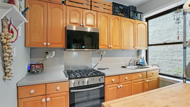a kitchen with stainless steel appliances granite countertop a sink stove and cabinets