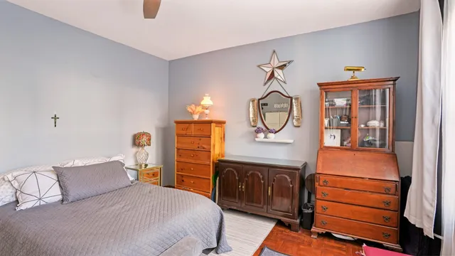 a bedroom with a bed a mirror on dresser and a chandelier