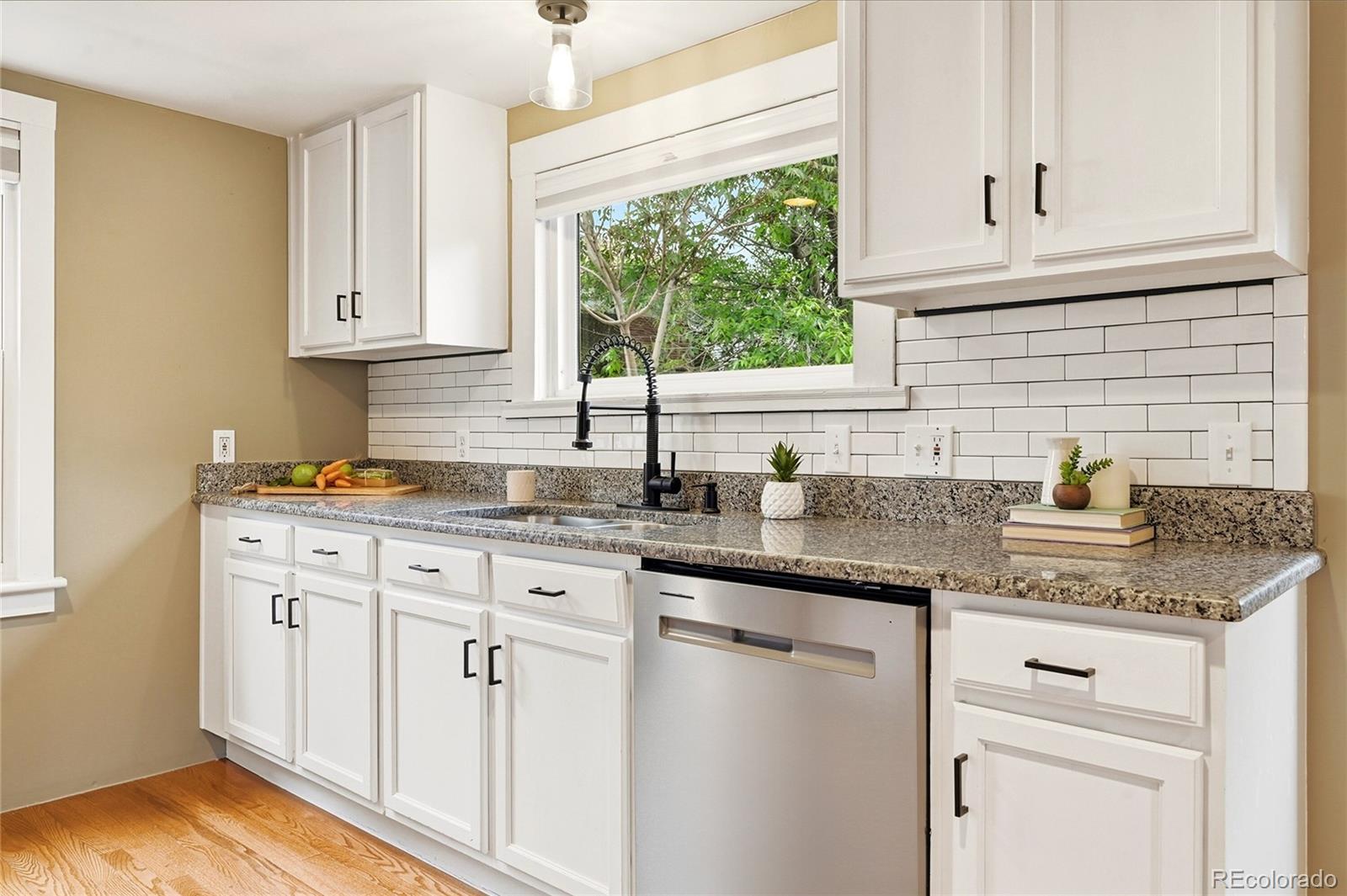 4546 Meade Street Denver, CO 80211 - Photo 12 of 35 a kitchen with granite countertop white cabinets white appliances and a sink
