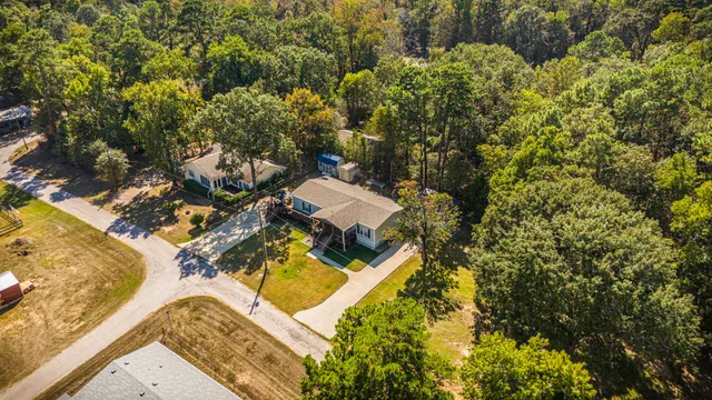 an aerial view of a house with swimming pool and large trees