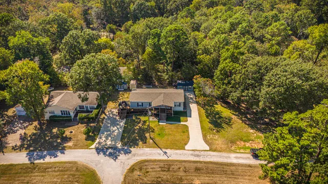 an aerial view of a house with a yard and trees