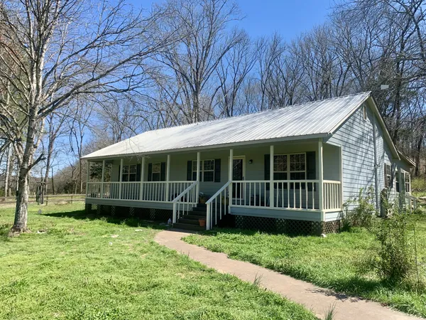 a view of a house with a yard and wooden fence