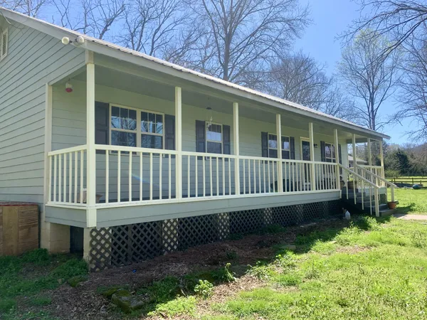 a view of a house with a yard and wooden fence
