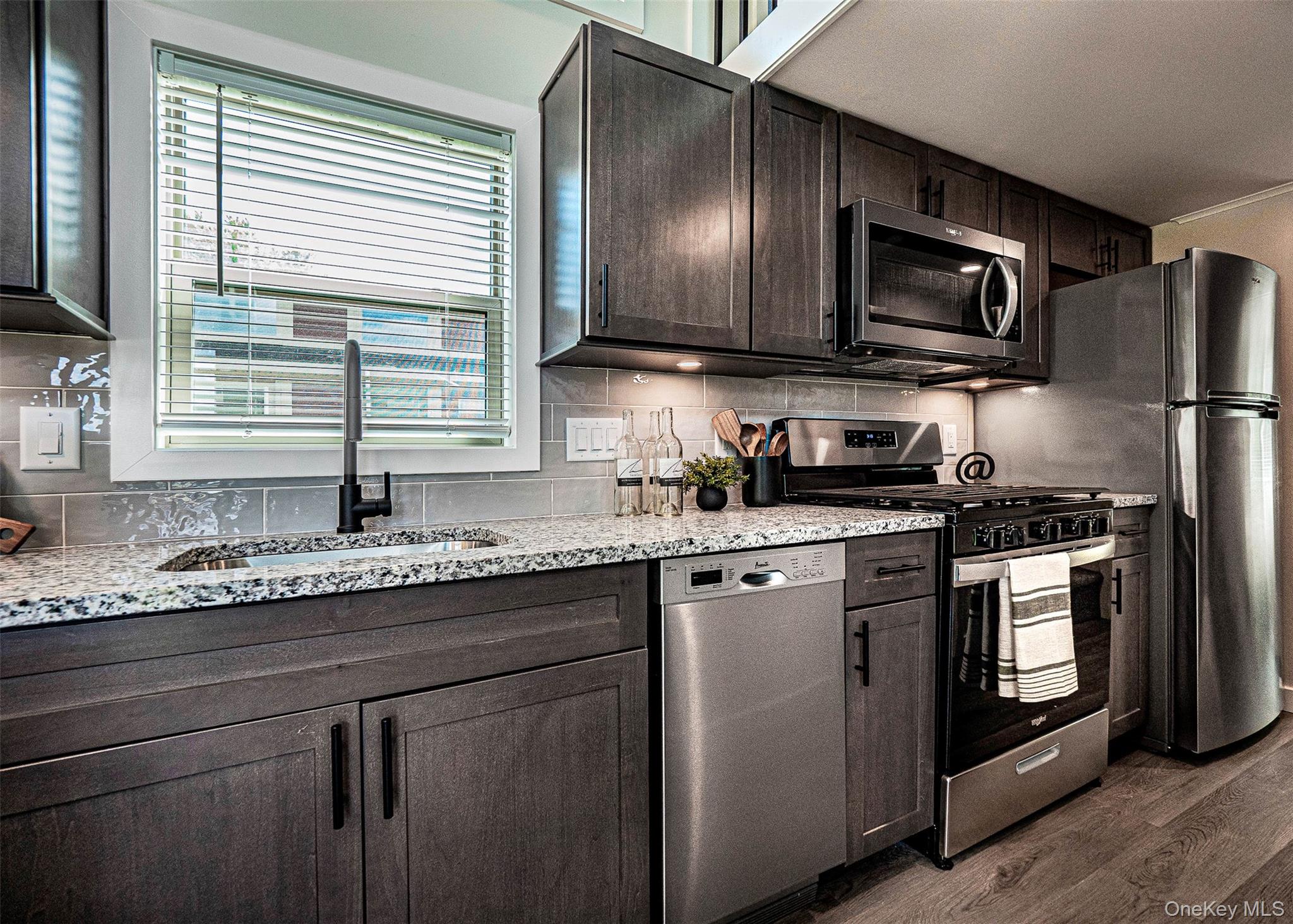 197 Wheeler Road, Unit 91 Florida, NY 10921 - Photo 10 of 48 Kitchen featuring appliances with stainless steel finishes, light stone countertops, tasteful backsplash, and dark brown cabinetry