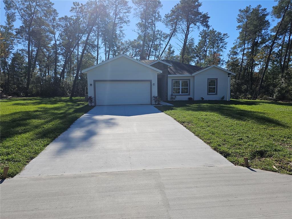 a front view of a house with a yard and trees