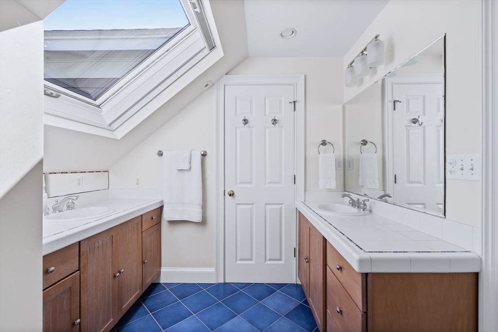86 Allen Farm Lane Concord, MA 01742 - Photo 21 of 34 a spacious bathroom with a double vanity sink a large mirror and a shower