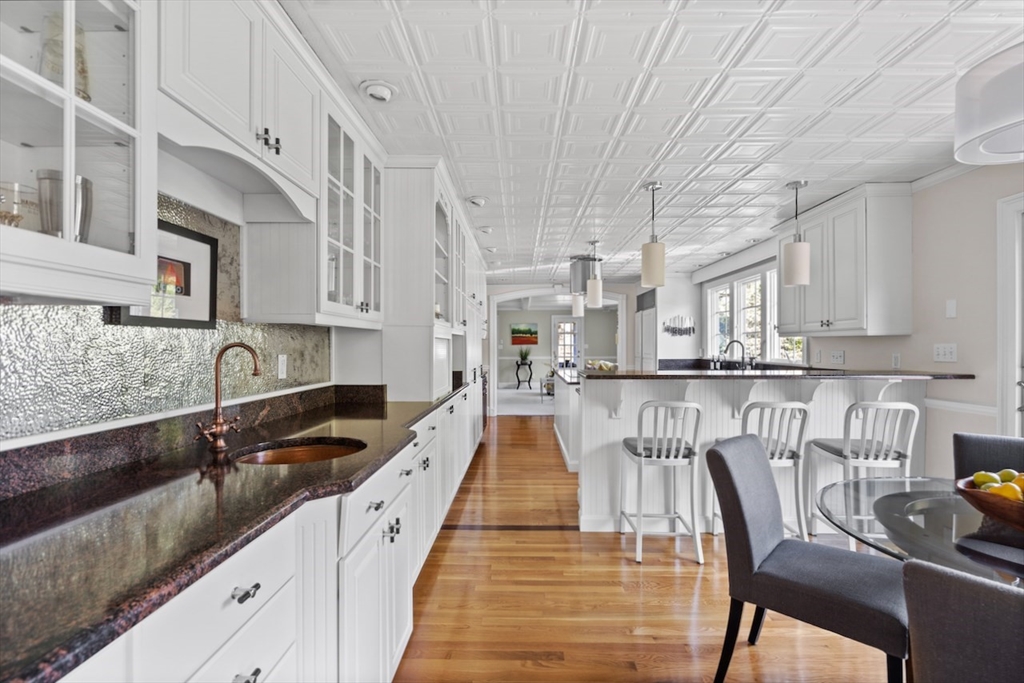 86 Allen Farm Lane Concord, MA 01742 - Photo 8 of 34 a kitchen with stainless steel appliances granite countertop a table chairs sink and cabinets