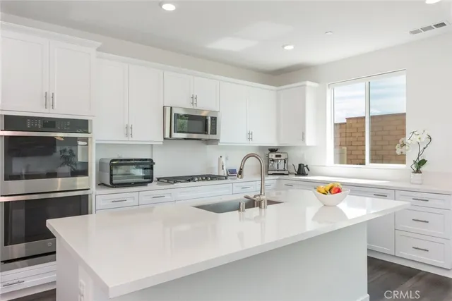 a kitchen with stainless steel appliances a sink a stove a microwave and cabinets