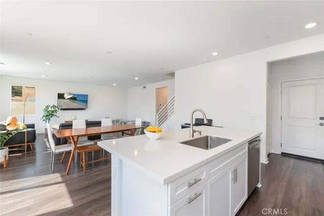 a open kitchen with stainless steel appliances granite countertop a sink and dishwasher with wooden floor