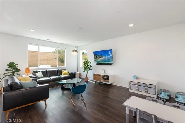 a living room with furniture a flat screen tv and a large window