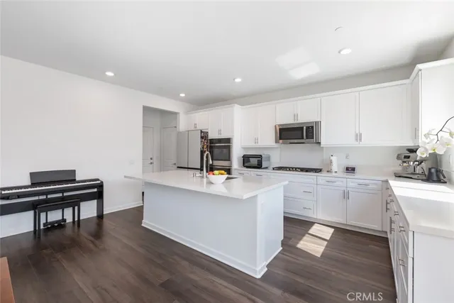 a kitchen with white cabinets and appliances