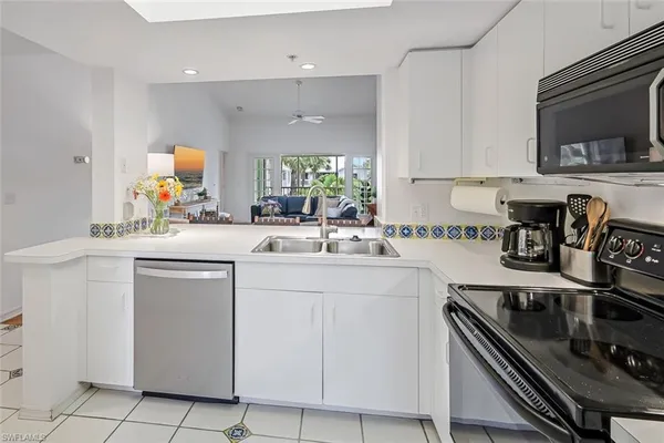 a kitchen with appliances a sink and cabinets
