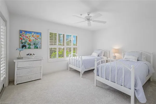 a spacious bedroom with two bed and a window