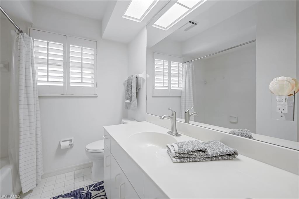 433 2nd Street South, Unit B202 Naples, FL 34102 - Photo 26 of 31 a bathroom with a granite countertop sink a toilet and a large mirror