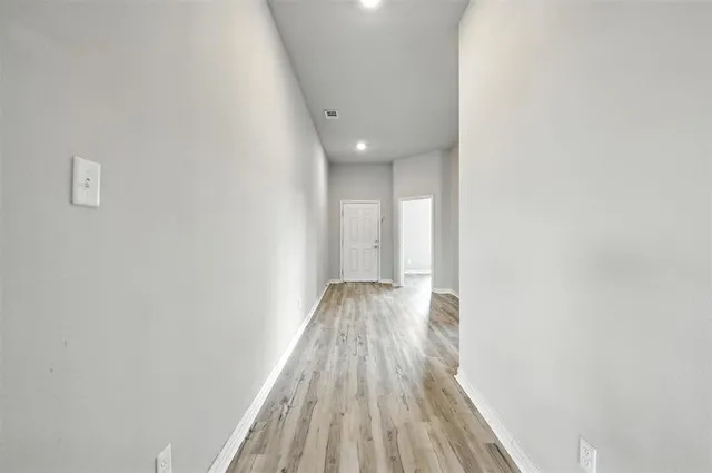 a view of hallway with wooden floor