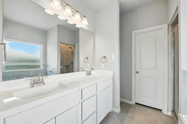 a bathroom with double vanity sinks and a mirror