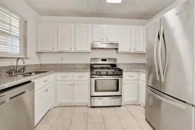 a kitchen with white cabinets and white appliances