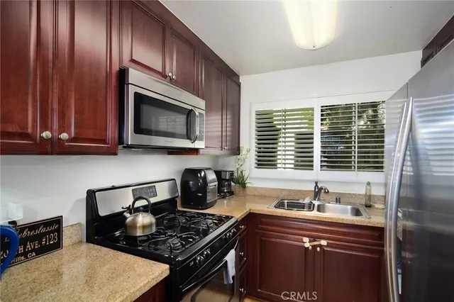 a kitchen with stainless steel appliances granite countertop a stove and a microwave