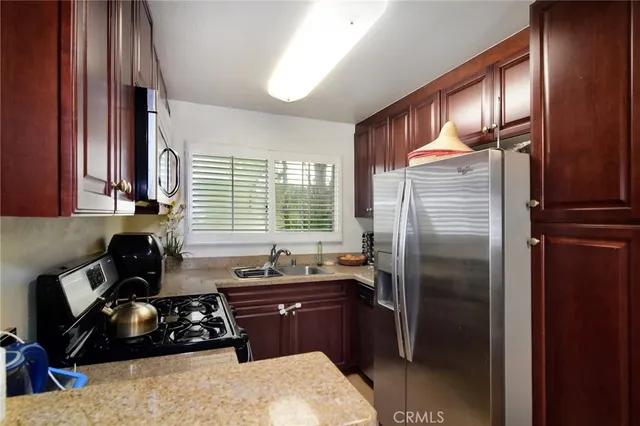 a kitchen with a refrigerator and a stove top oven