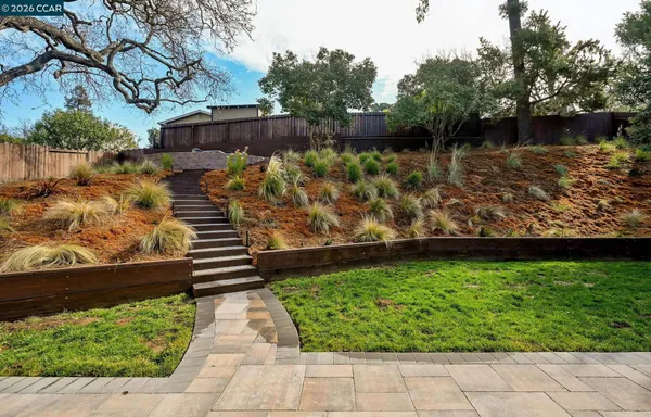 a view of a yard with wooden fence