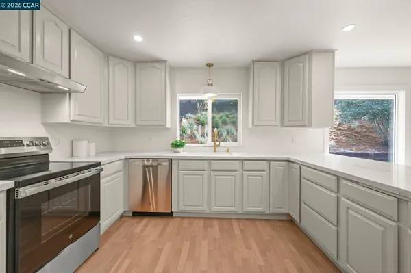 a kitchen with a white cabinets and window