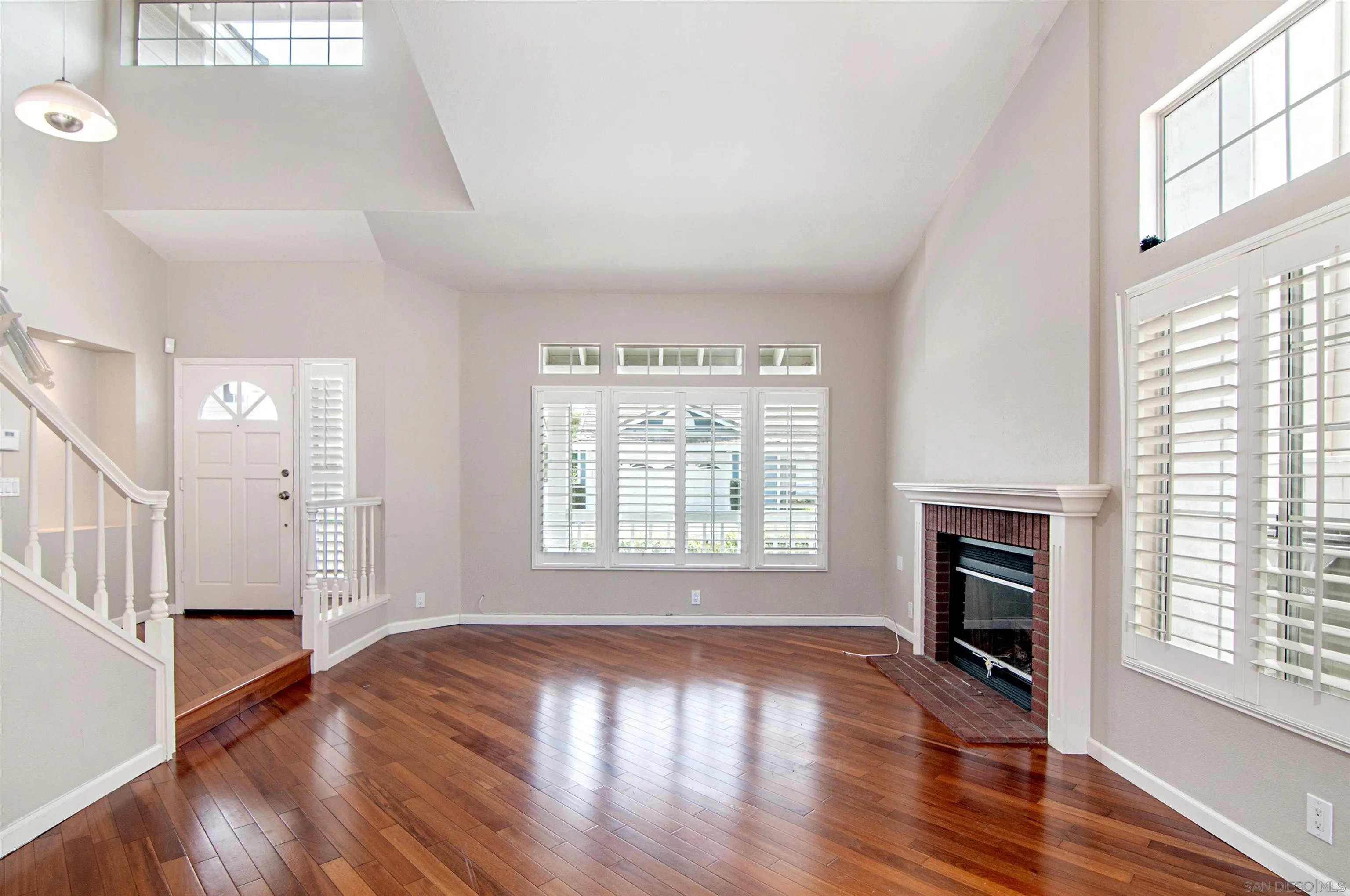14530 Rutledge Square San Diego, CA 92128 - Photo 4 of 4 an empty room with wooden floor fireplace and windows