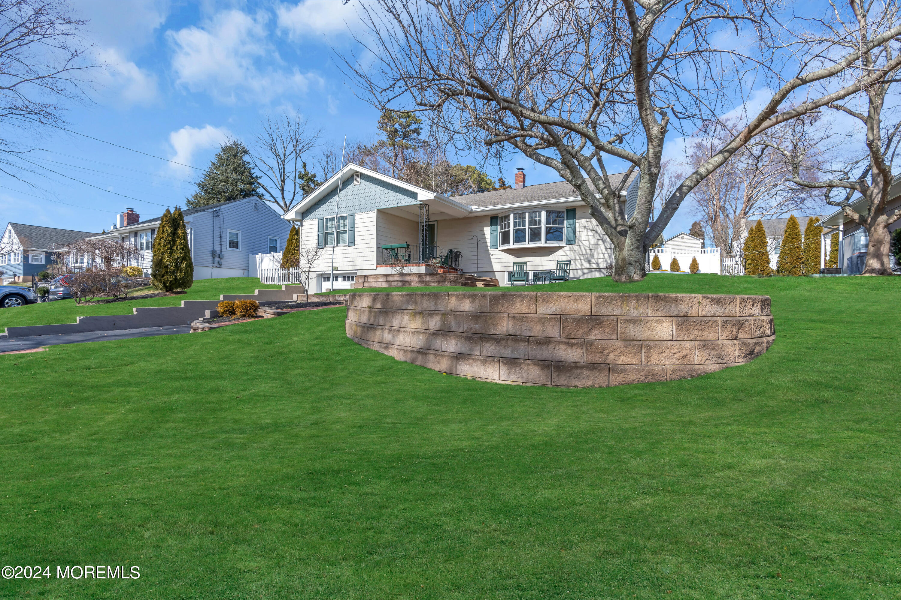 1120 Mohegan Road Manasquan, NJ 08736 - Photo 3 of 38 a front view of a house with a garden and trees