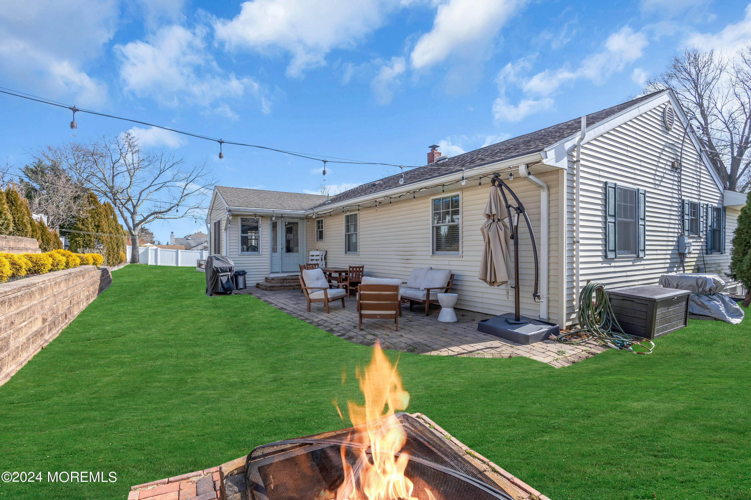 1120 Mohegan Road Manasquan, NJ 08736 - Photo 5 of 38 a view of a backyard with table and chairs potted plants and a big yard