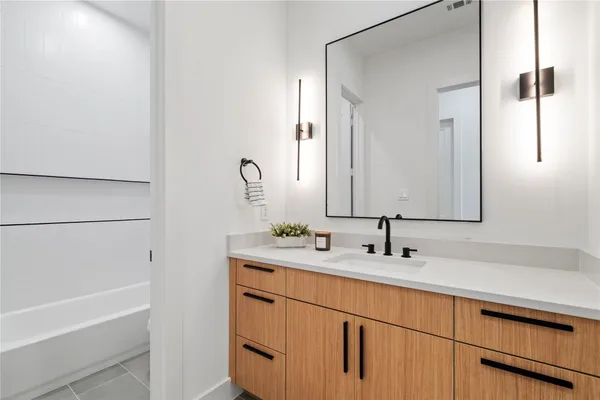 a bathroom with a double vanity sink and a bathtub