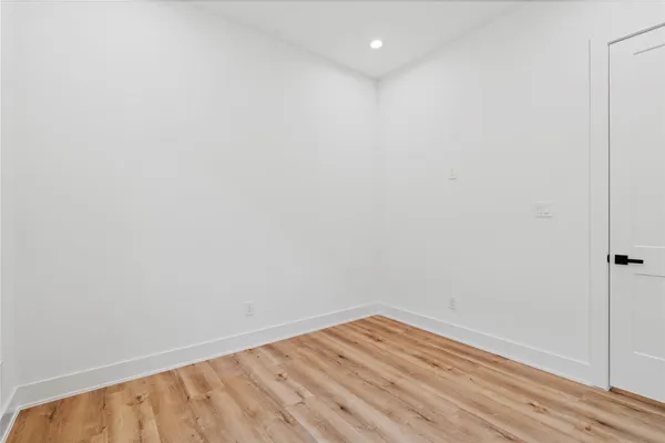 a view of an empty room with wooden floor
