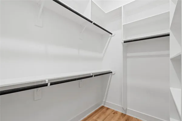 a view of walk in closet with wooden floor