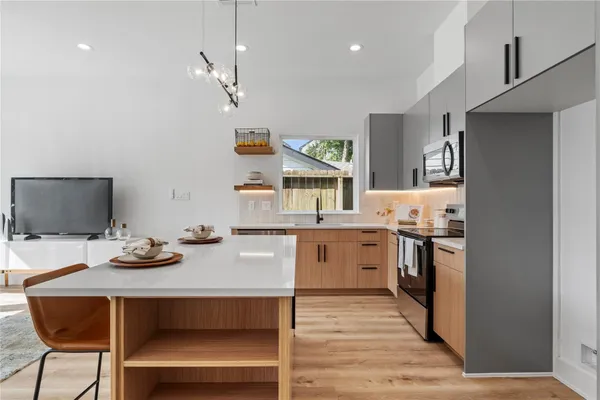 a kitchen with a table chairs refrigerator and microwave