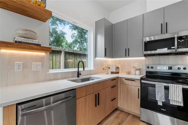 a kitchen with stainless steel appliances granite countertop a sink a stove and a microwave