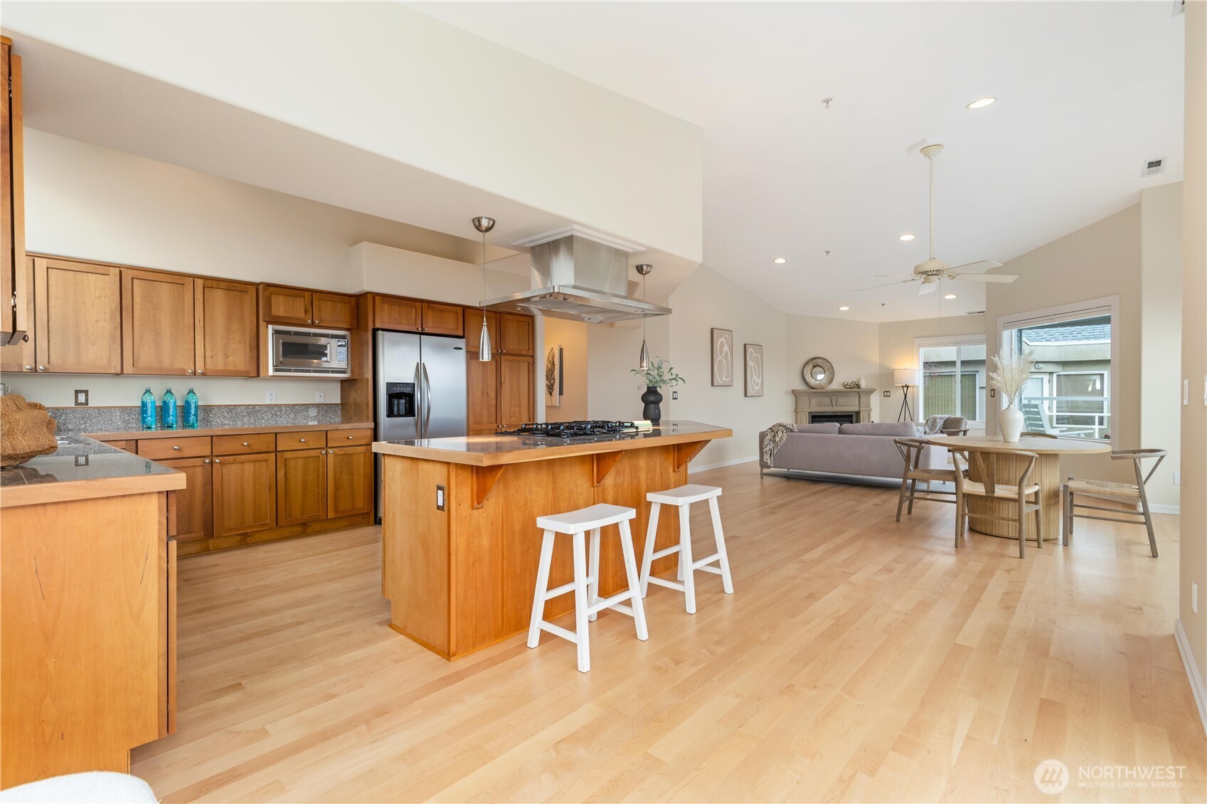 550 Dayton Street, Unit 201 Edmonds, WA 98020 - Photo 19 of 38 a kitchen with stainless steel appliances granite countertop a stove top oven a sink a dining table and chairs with wooden floor