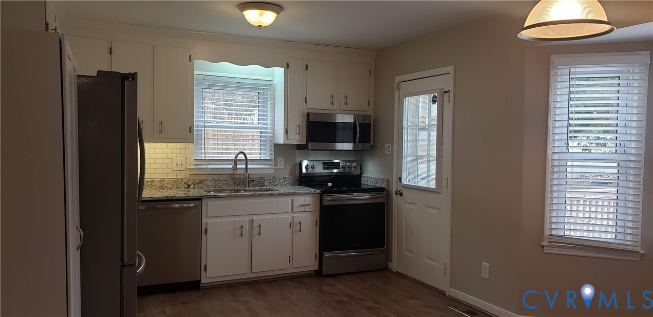 7166 Full Rack Drive Midlothian, VA 23112 - Photo 4 of 19 a kitchen with granite countertop stainless steel appliances a sink stove and refrigerator