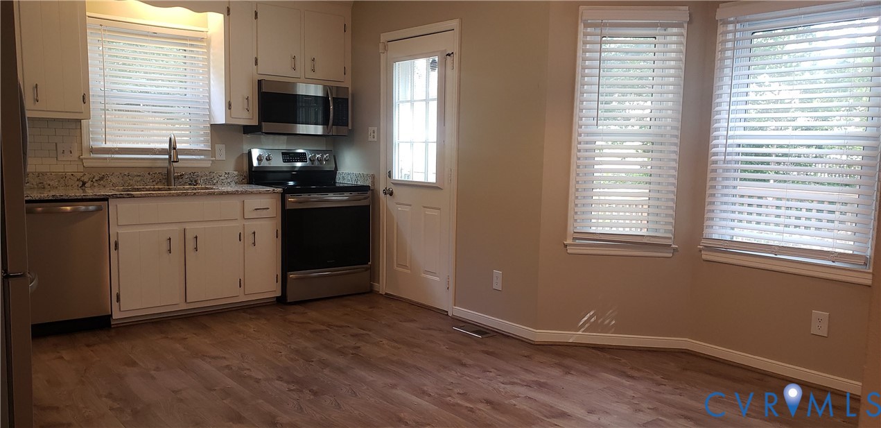 7166 Full Rack Drive Midlothian, VA 23112 - Photo 5 of 19 a kitchen with a sink wooden floor and a stove top oven
