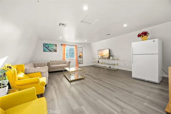 a living room with furniture and a wooden floor
