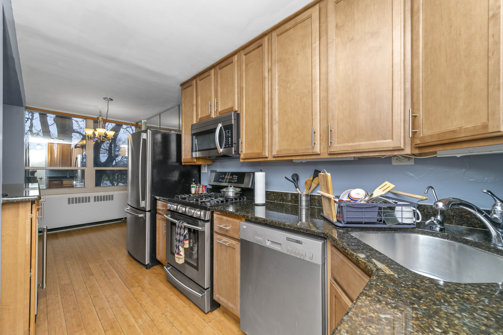 3950 North Lake Shore Drive, Unit 228 Chicago, IL 60613 - Photo 7 of 28 a kitchen with stainless steel appliances granite countertop a sink a stove and a wooden cabinets